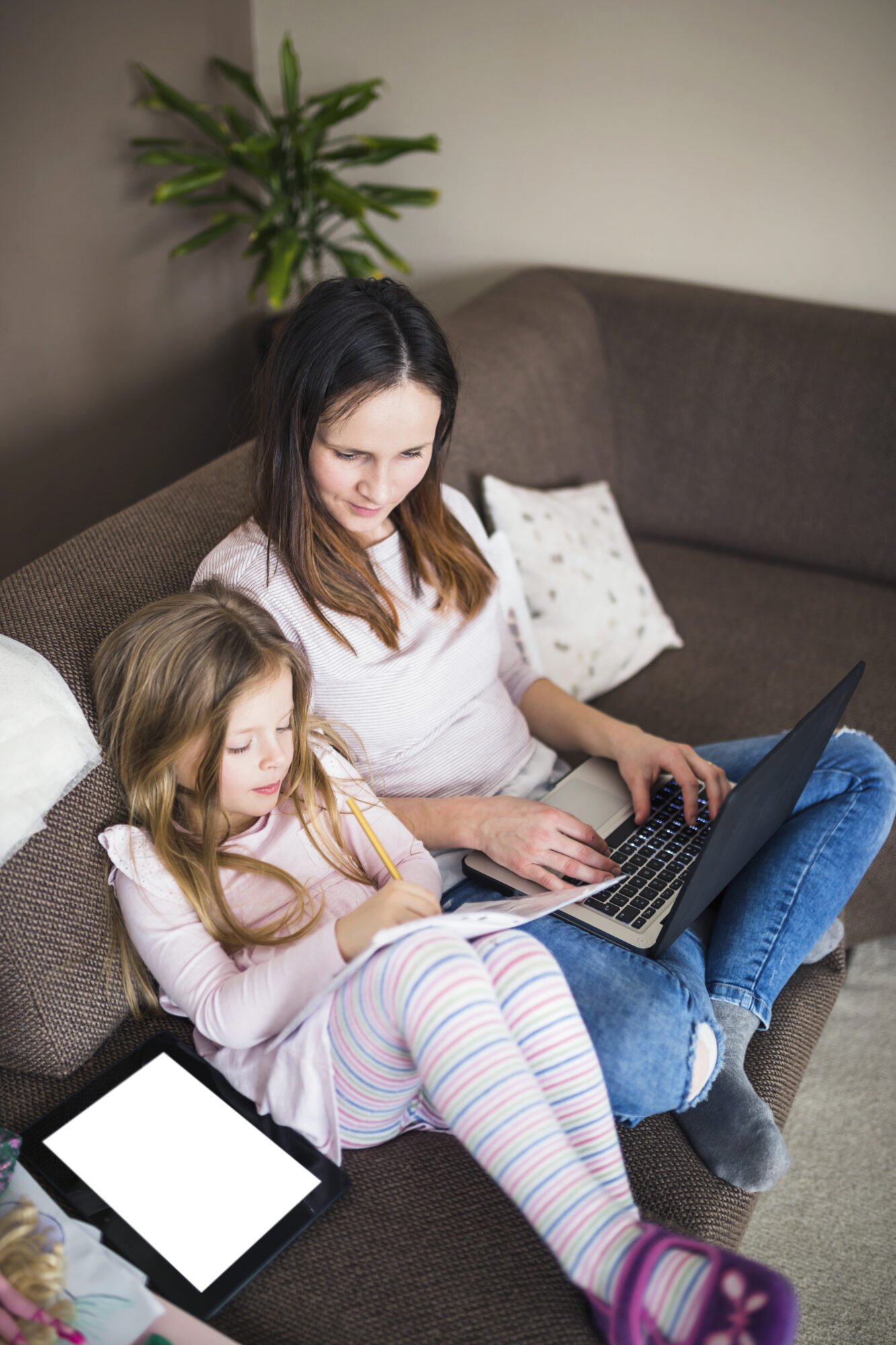 woman with laptop looking her daughter studying